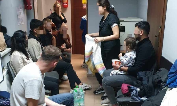 kobiety, mężczyźni i dziecko w komisariacie Policji
