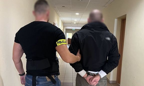 Policjant prowadzi zatrzymanego