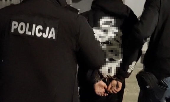 dwaj policjanci prowadzą zatrzymanego