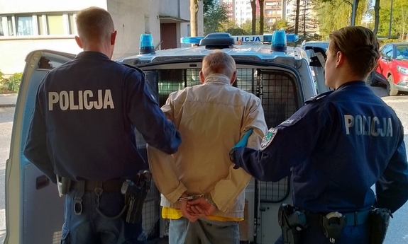 Zdjęcie przedstawiające dwóch policjantów oraz zatrzymanego mężczyznę