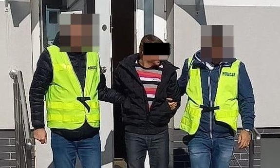 dwaj policjanci prowadzą zatrzymanego