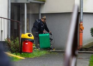 policjantka pomaga wyjść kobiecie z budynku