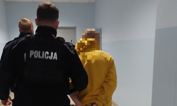 policjant prowadzi zatrzymanego