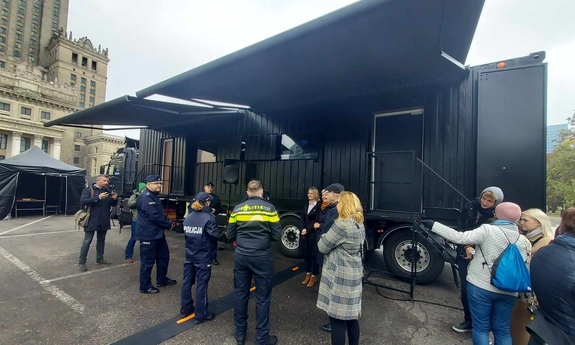 Przedstawiciele Policji polskiej i holenderskiej wraz z uczestnikami inauguracji projektu stoją obok escapetrucka.