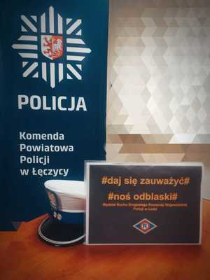 Plakat daj się zauważyć stoi na stoliku. W tle napis Policja, Komenda Powiatowa Policji w Łęczycy