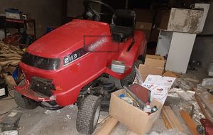 Skradzione rzeczy zostawione w pustostanie, między innymi czerwony traktor do koszenia trawy, smary, akumulatory
