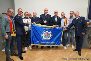 grupa osób z niebieską flagą w pomieszczeniu