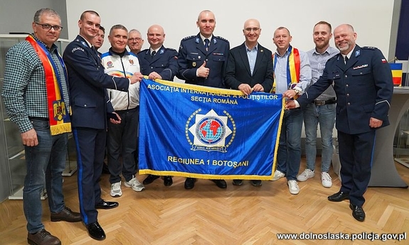 grupa osób z niebieską flagą w pomieszczeniu