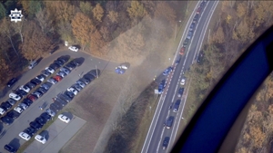 widok na drogę i parking przy cmentarzu z lecącego śmigłowca