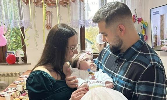 Rodzice trzymają na rękach swoją córkę, Marcelinę
