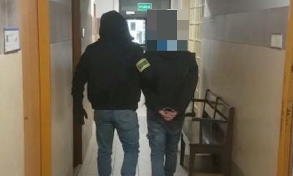 policjant prowadzi zatrzymanego mężczyznę