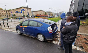 trzy osoby stojące przy taksówce