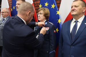 Mężczyzna przypina medal kobiecie