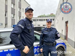 policjant i policjantka przy radiowozie