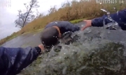 policjanci wyciągają kobietę z wody