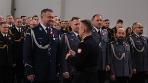 Komendant Główny Państwowej Straży Pożarnej wręcza medal policjantowi