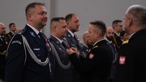 Komendant Główny Państwowej Straży Pożarnej wręcza medal policjantowi