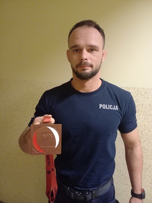 Młodszy aspirant Karol Kurembski prezentuje medal