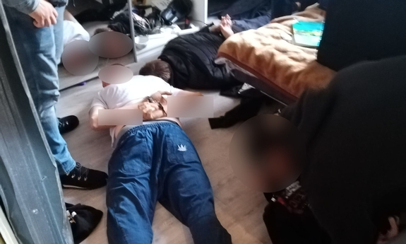 zatrzymani leżą na podłodze z założonymi kajdankami