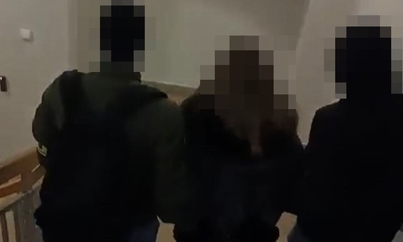 dwóch policjantów prowadzi zatrzymaną kobietę
