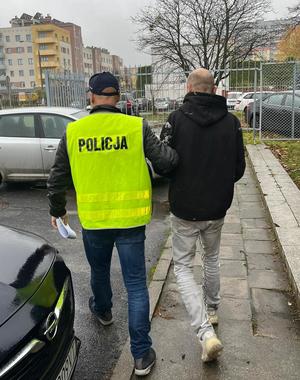 policjant prowadzi zatrzymanego