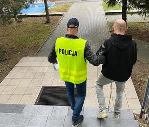 policjant prowadzi zatrzymanego