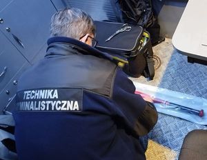 Plecy policjanta, który coś sprawdza