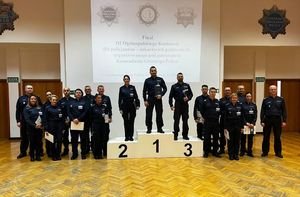 policjanci najlepsi uczestnicy konkursu stoją na podium i obok niego