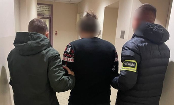 dwaj policjanci prowadzą zatrzymanego