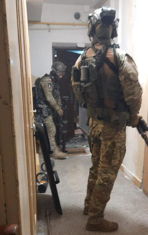 uzbrojeni policjanci na korytarzu w budynku