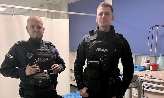 Dwaj umundurowani policjanci pozują do zdjęcia