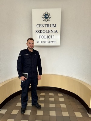 policjant stroi na tle napisu Centrum Szkolenia Policji w Legionowie