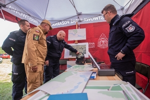 policjanci w namiocie, na stole leżą mapy