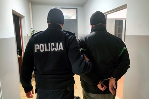 Zatrzymany mężczyzna prowadzony przez policjanta