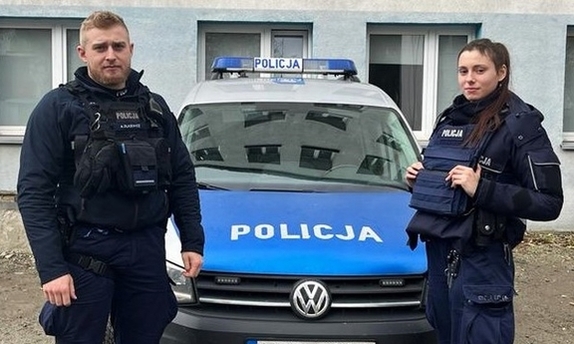 policjant i policjantka przy radiowozie