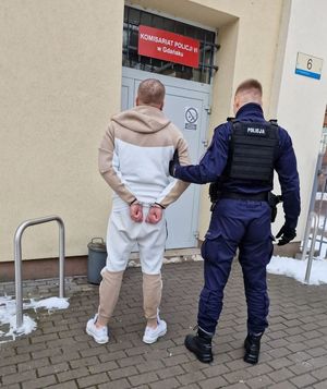 Policjant prowadzi zatrzymanego