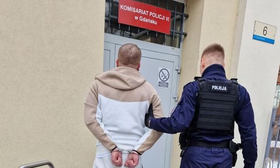 Policjant prowadzi zatrzymanego