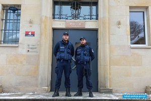 Dwóch policjantów stoi na tle budynku policji