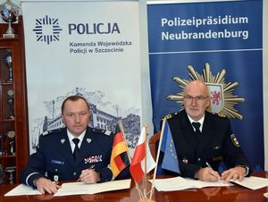 Policjanci siedzą i coś podpisują