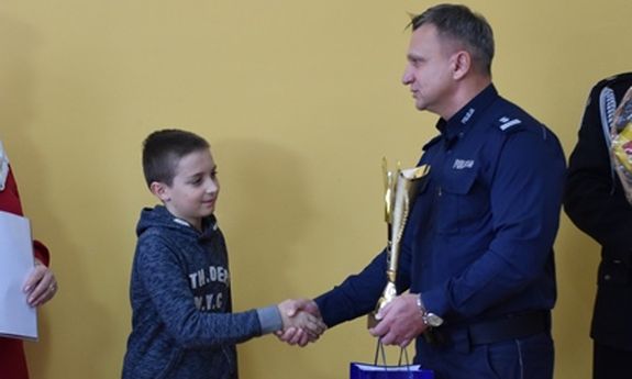 Policjant podaje rękę chłopcu