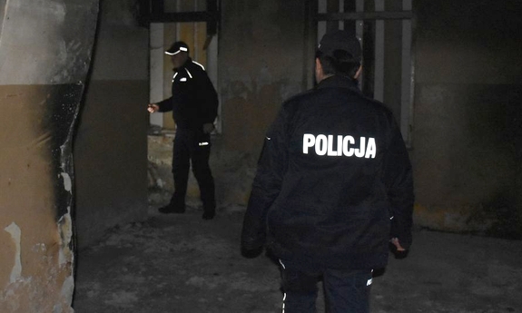 Policjanci kontrolują opuszczony budynek
