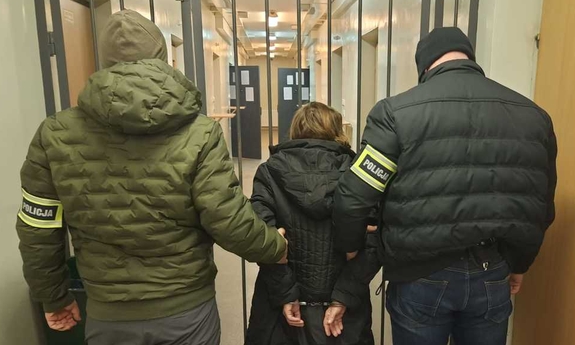 policjanci trzymają zatrzymaną kobietę