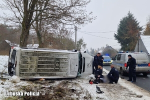 Dach wywróconego na bok busa, obok radiowóz