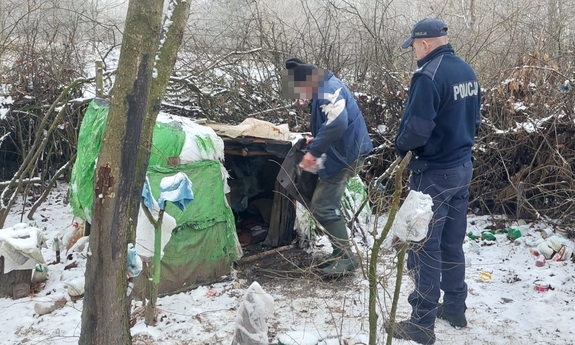 policjant i mężczyzna stoją przy prowizorycznym namiocie