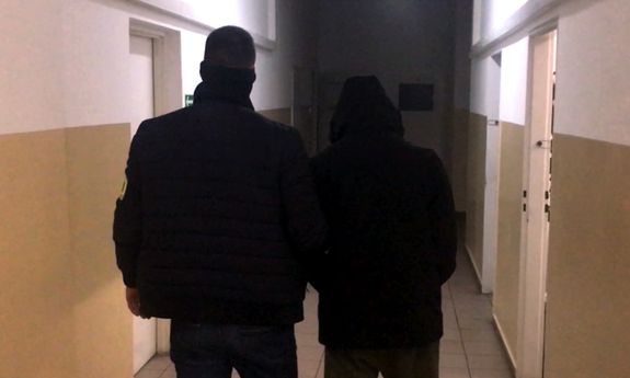 Policjant prowadzi zatrzymanego