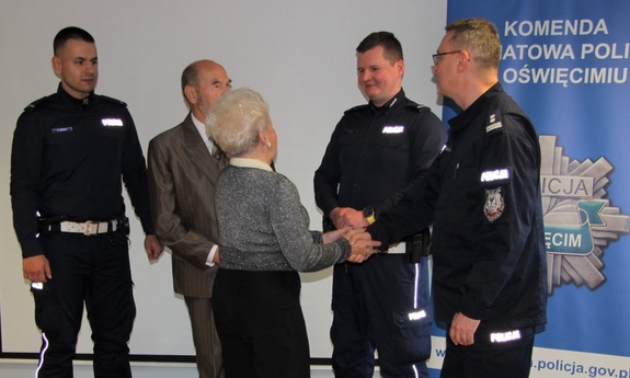 Sala szkoleniowa. Policjanci i seniorzy na wspólnym zdjęciu