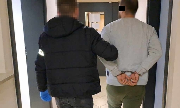 policjant prowadzi zatrzymanego