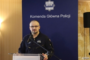 policjant stoi przy mównicy