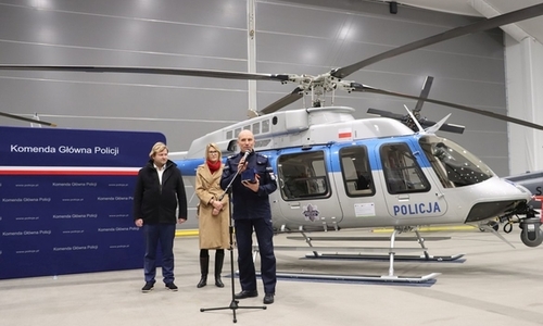 Zastępca Komendanta Głównego Policji przemawia do mikrofonu, w tle śmigłowiec