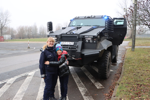 Bartek i policjantka, w tle pojazd opancerzony